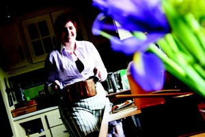 Mona Wise carrying a hot pot in her kitchen